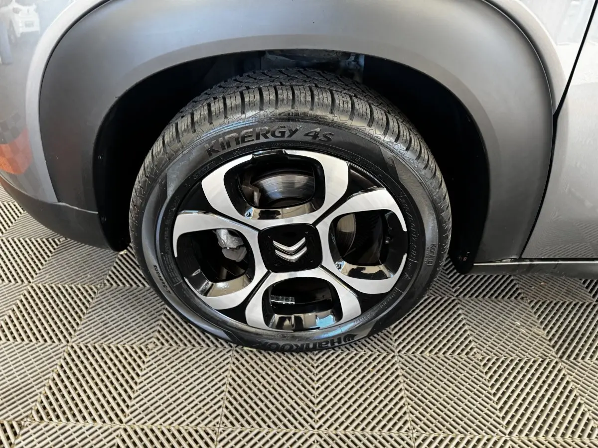 Gros plan sur la roue avant droite gris foncé d'une Citroën C3 2019 avec jante noire et argentée au design distinctif.