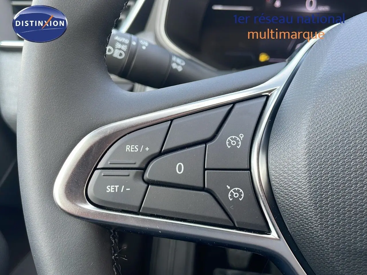 Gros plan sur les commandes de régulateur de vitesse au volant d'une Renault Clio noire étoile métal 2025.