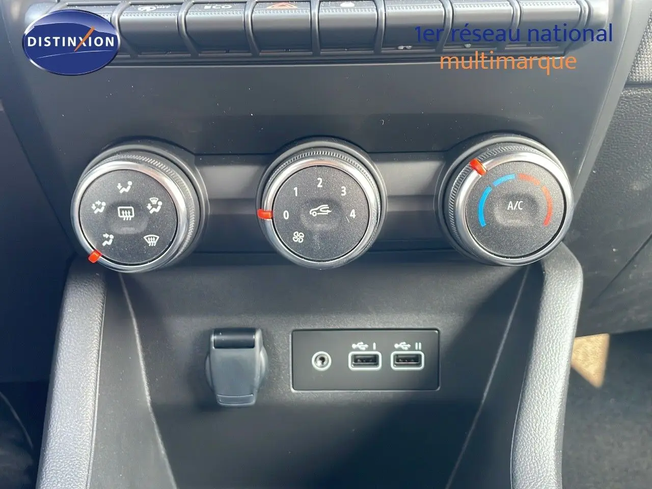 Gros plan sur les commandes de climatisation et les ports USB d'une Renault Clio 1.5 DCI 100ch Evolution noir étoile métal.