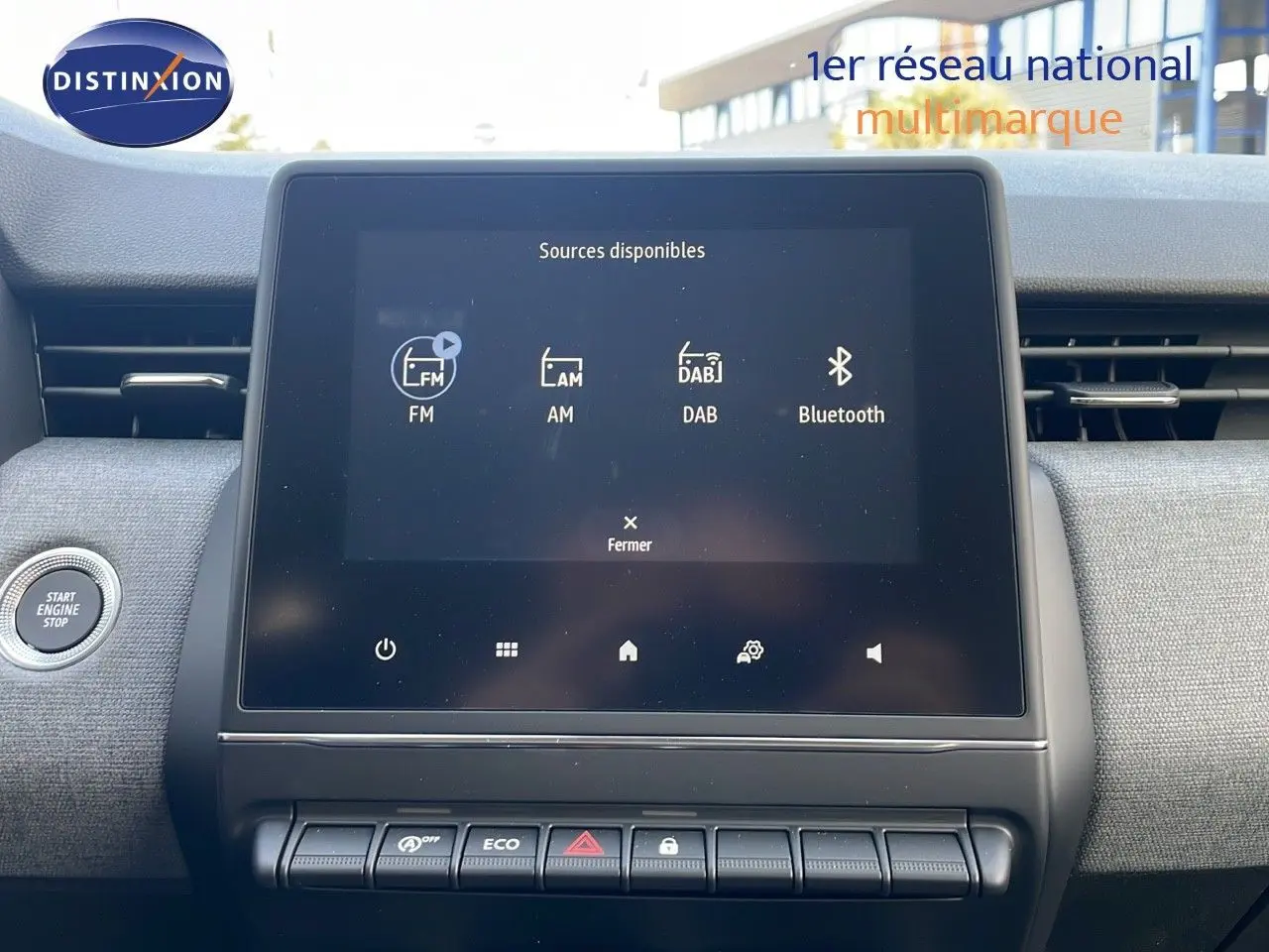 Écran tactile central de la Renault Clio 1.5 DCI 100ch Evolution 2025 avec commandes et bouton start/stop visibles.