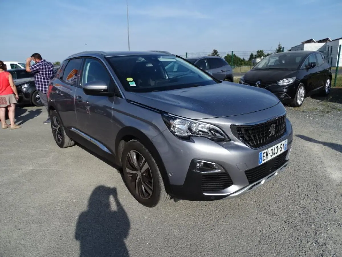 Peugeot 3008 gris Artense en 3/4 avant droit, avec barres de toit aluminium et jantes noires distinctives.