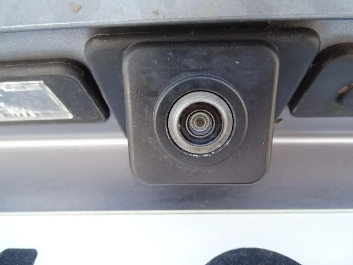 Gros plan sur la caméra de recul noire intégrée au hayon arrière du Peugeot 3008 gris Artense de 2017.