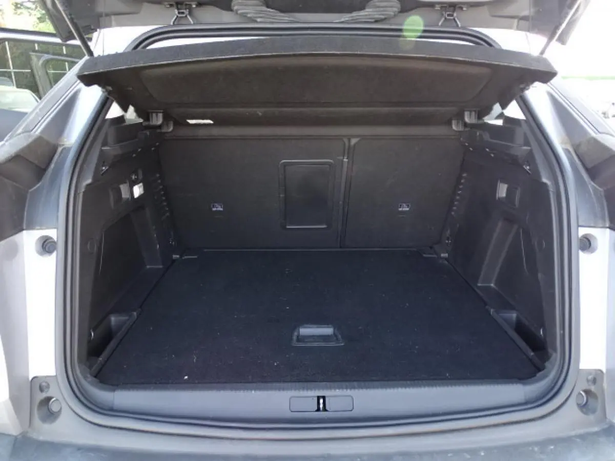 Coffre ouvert du Peugeot 3008 gris Artense, vue arrière montrant l'espace de chargement vide et la tablette de couverture relevée.