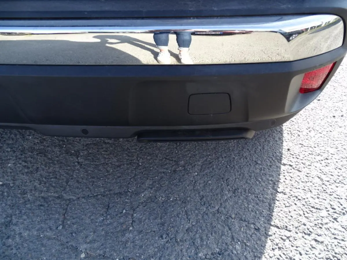 Gros plan sur le pare-chocs arrière gris Artense du Peugeot 3008 2017 avec feu rouge et capteurs de stationnement visibles.