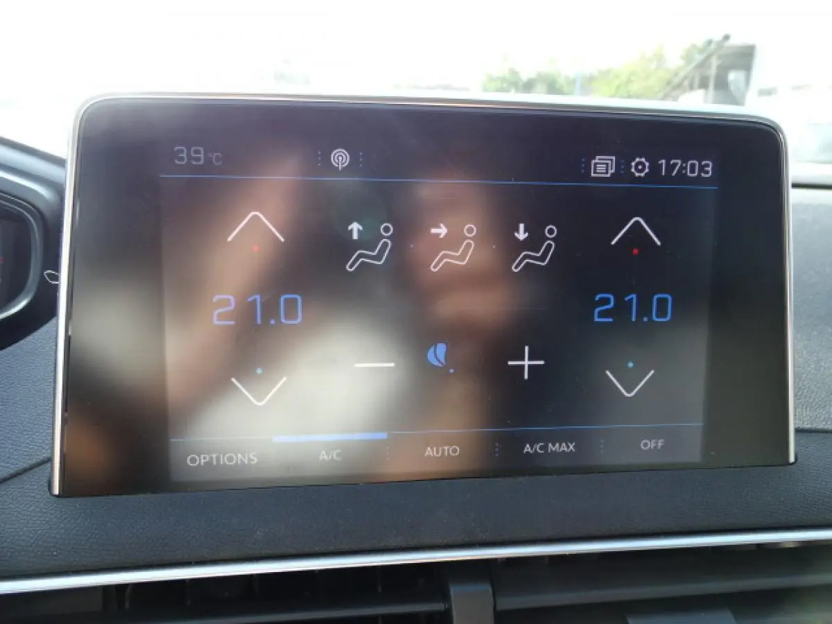 Écran tactile du tableau de bord du Peugeot 3008 2017 montrant la climatisation automatique bi-zone réglée à 21°C.