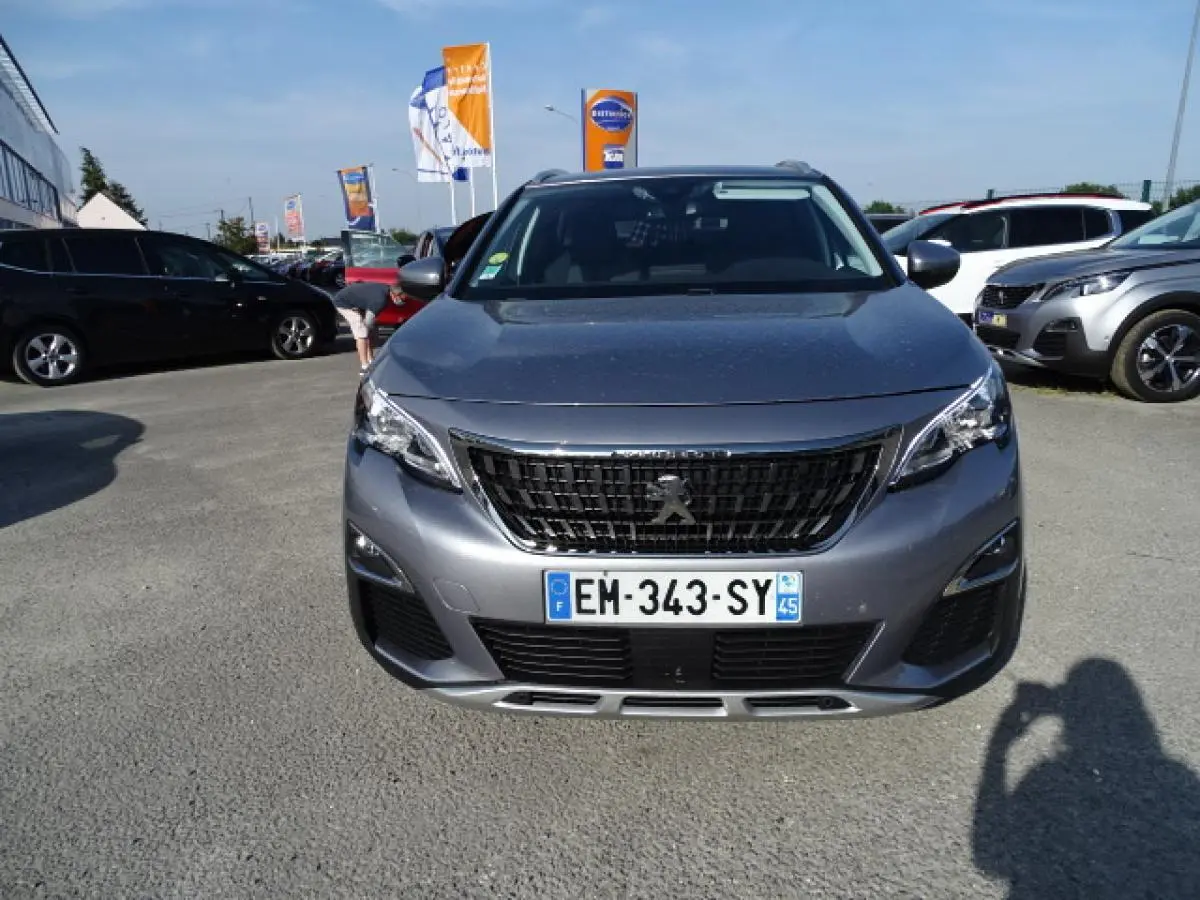 Vue frontale d'un Peugeot 3008 gris Artense avec calandre noire et plaques d'immatriculation françaises visibles.
