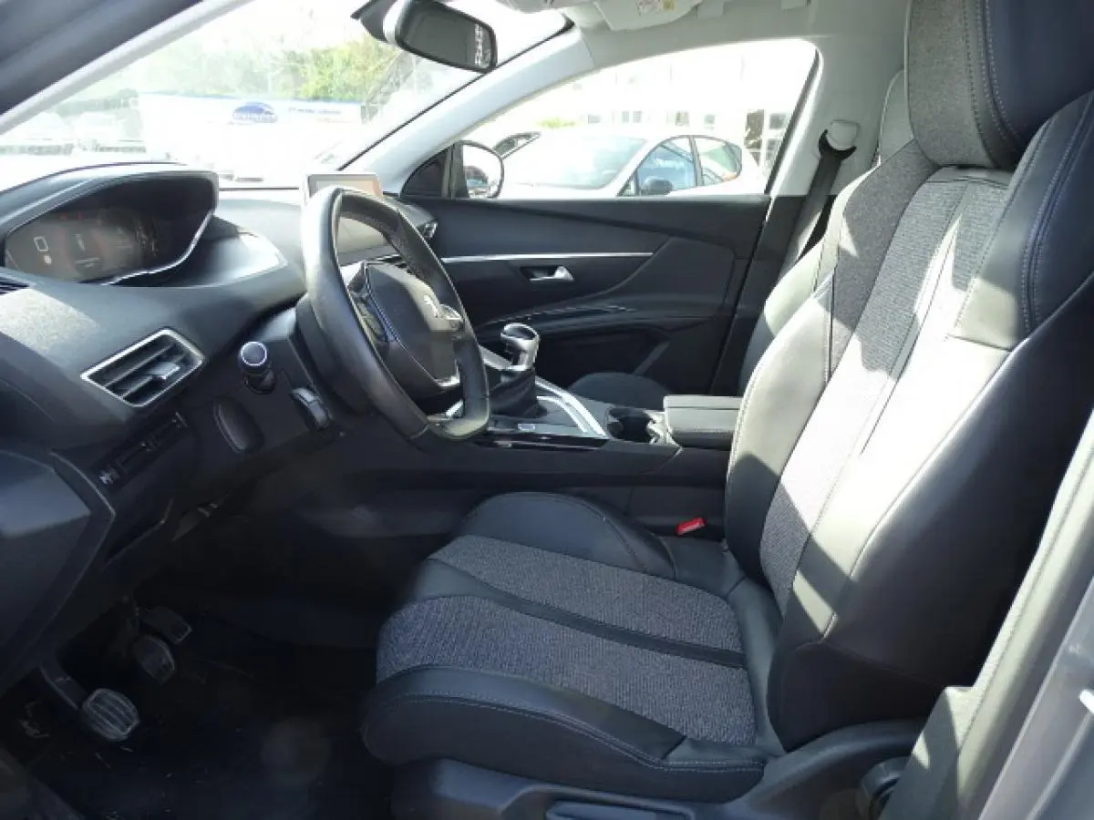 Intérieur du Peugeot 3008 2017 vu côté conducteur, sièges tissu et cuir noirs avec tableau de bord moderne.