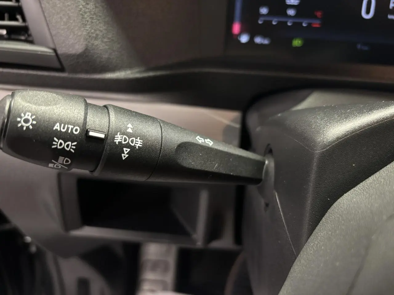 Gros plan sur la manette de commande des feux et clignotants du FIAT Scudo Fourgon gris foncé, intérieur tableau de bord.