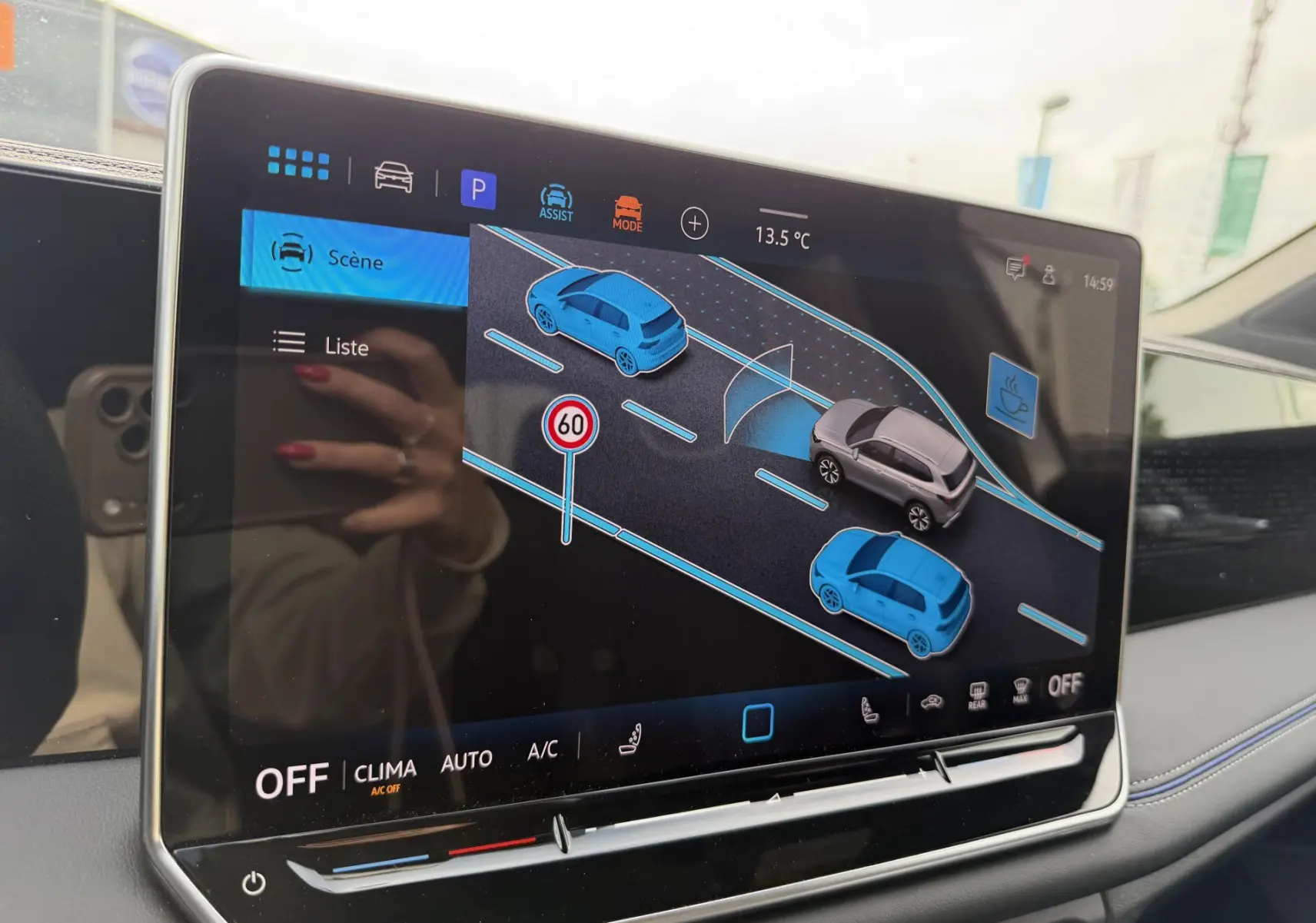 Écran tactile intérieur du Volkswagen Tiguan 2025 montrant l'aide au stationnement avec visualisation des véhicules autour.