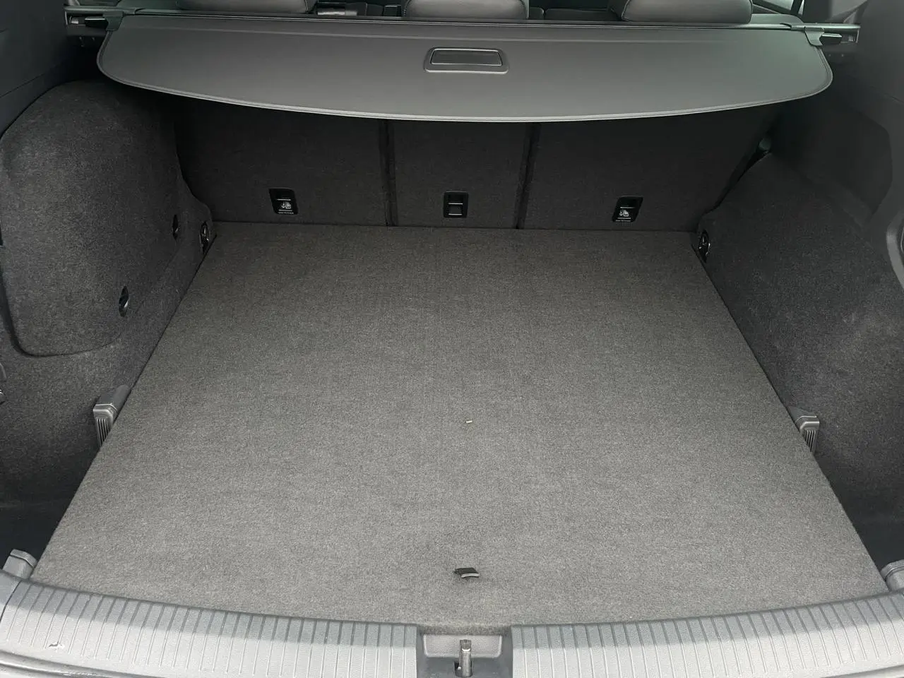 Coffre spacieux du SEAT Tarraco 1.4 e-Hybrid 245 DSG6 FR vu de l'arrière, intérieur gris foncé avec hayon fermé.