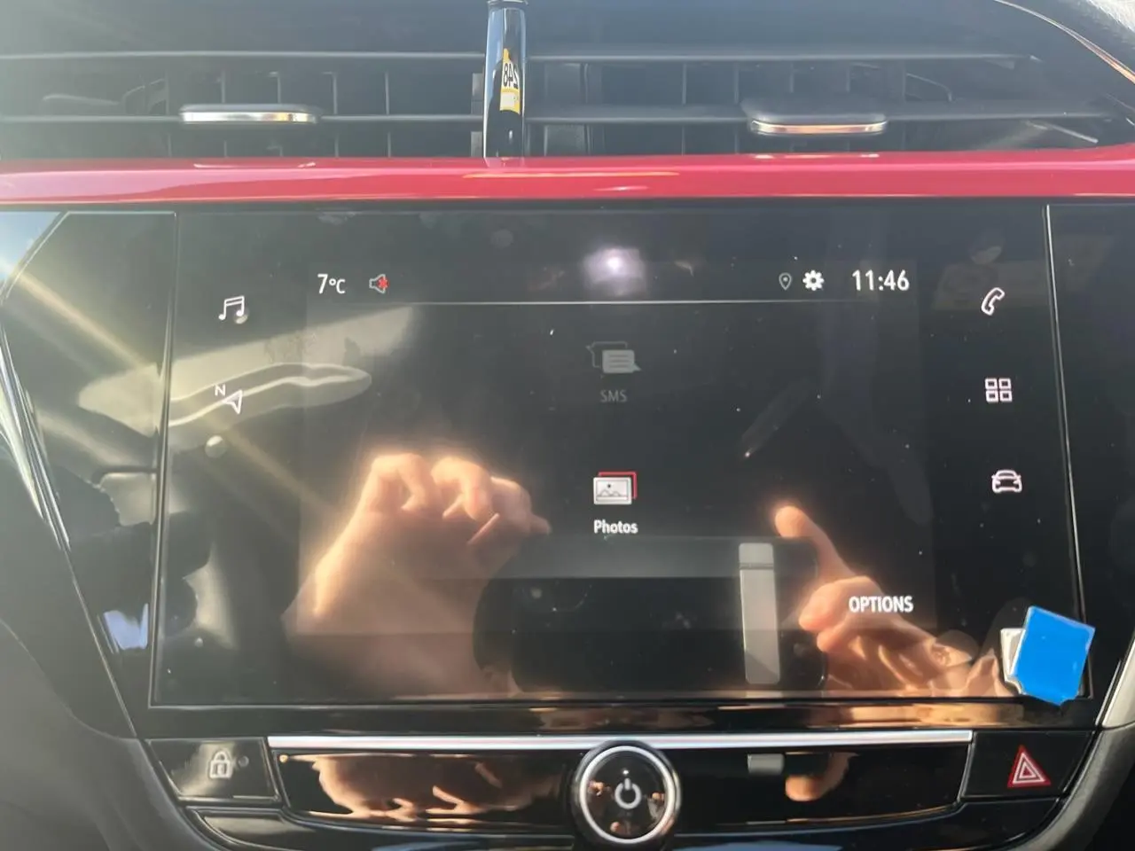 Écran tactile couleur 7 pouces de l'Opel Corsa GS Line 2022 avec reflet de mains et tableau de bord noir.