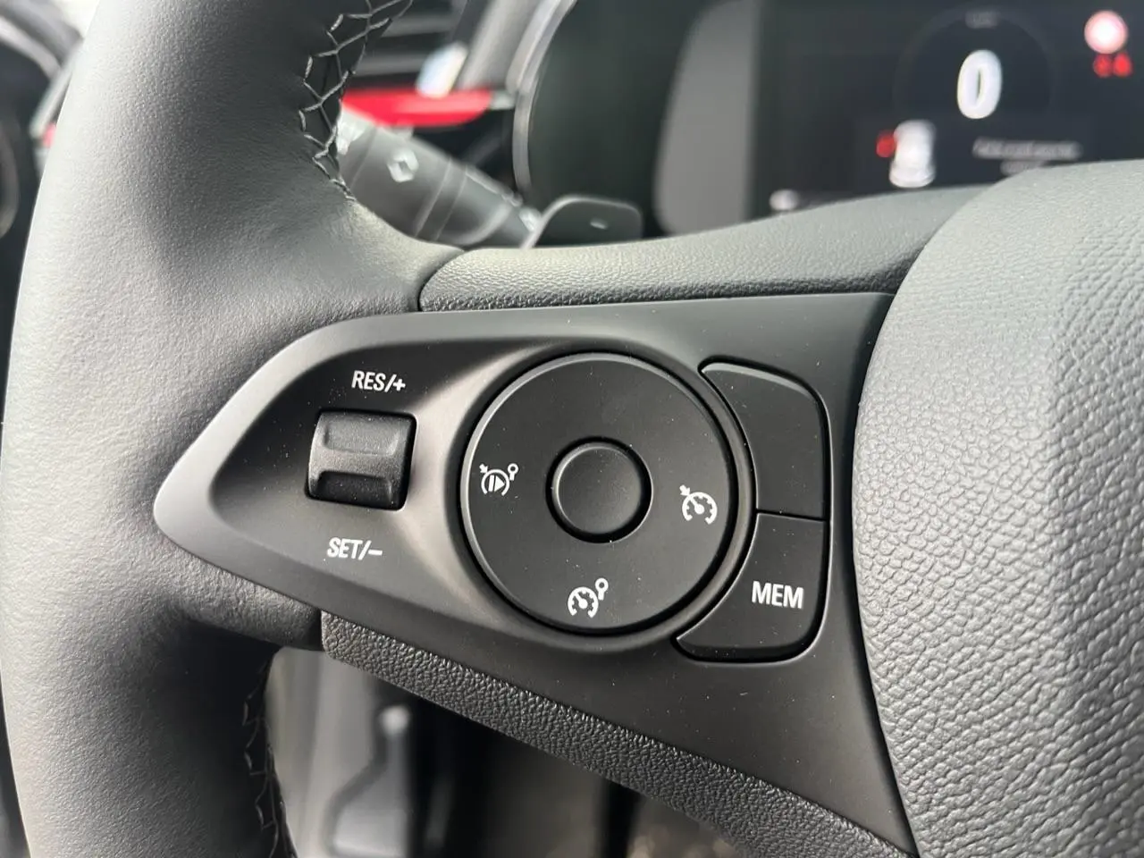 Gros plan sur les commandes du régulateur de vitesse au volant multifonction noir de l'Opel Corsa GS Line 2022.