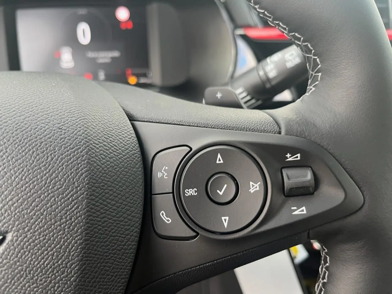 Gros plan sur les commandes du volant à droite de l’Opel Corsa GS Line 2022 noire, avec boutons multifonctions et palettes au volant.