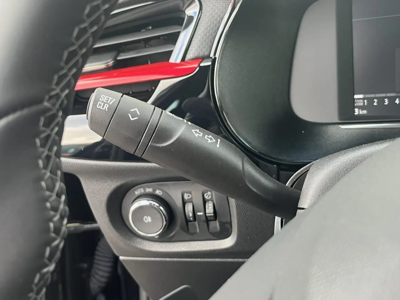 Gros plan sur la commande de clignotant et les réglages d'éclairage du tableau de bord noir de l'Opel Corsa GS Line.