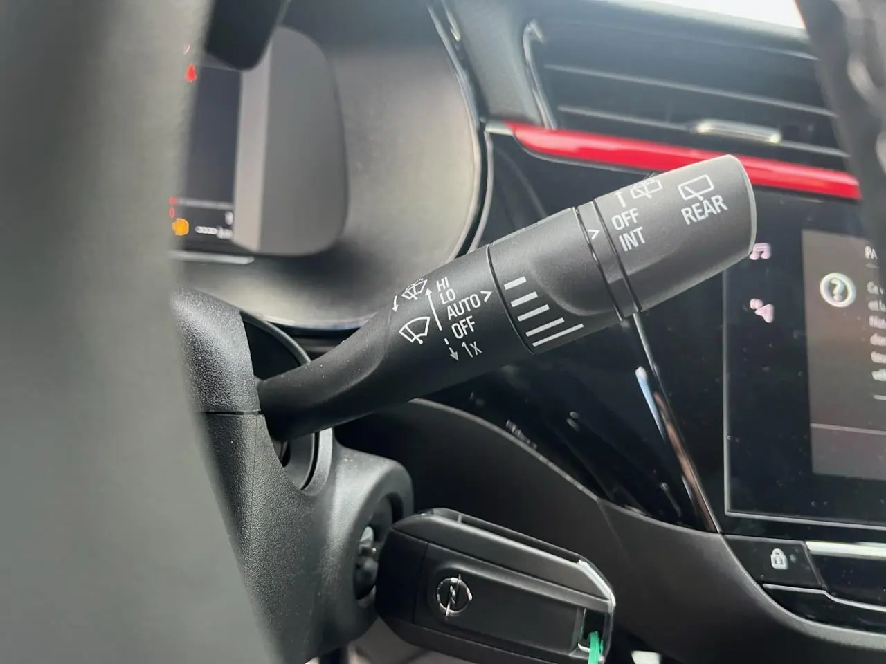 Gros plan sur la commande d'essuie-glace côté droit du volant d'une Opel Corsa GS Line noire avec tableau de bord et écran tactile.