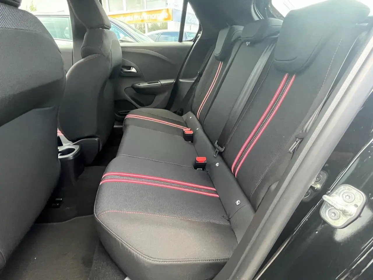 Vue intérieure côté droit des sièges arrière noirs avec surpiqûres rouges de l'Opel Corsa GS Line 2022.