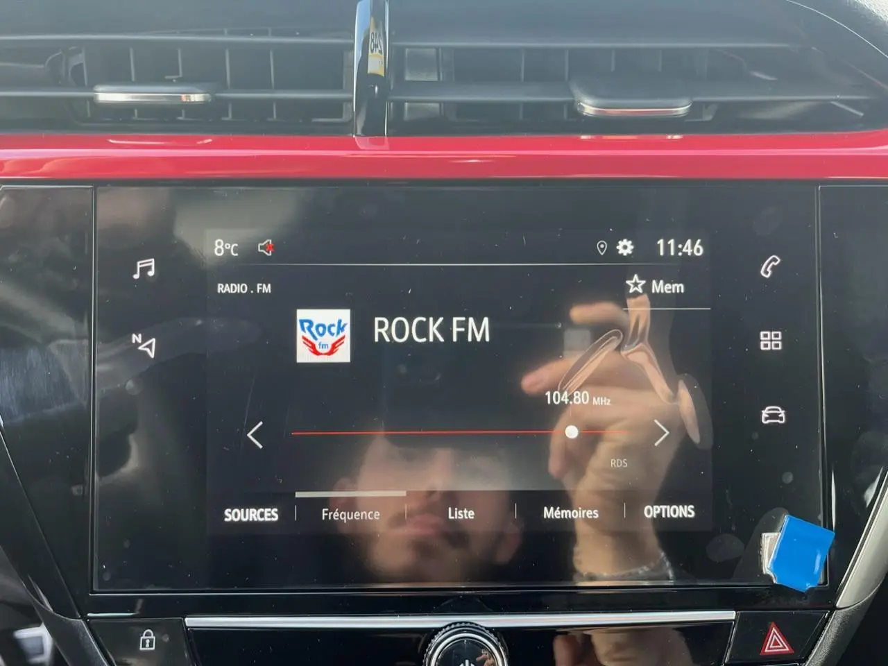 Écran tactile 7 pouces de l'Opel Corsa GS Line 2022 affichant la radio Rock FM en intérieur noir et rouge.