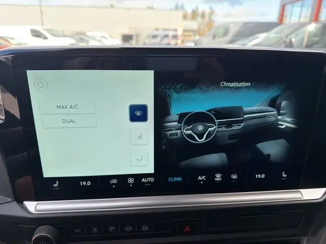 Écran tactile du tableau de bord du Volkswagen Transporter ProCab 2026 affichant les réglages de climatisation et une vue intérieure digitale.