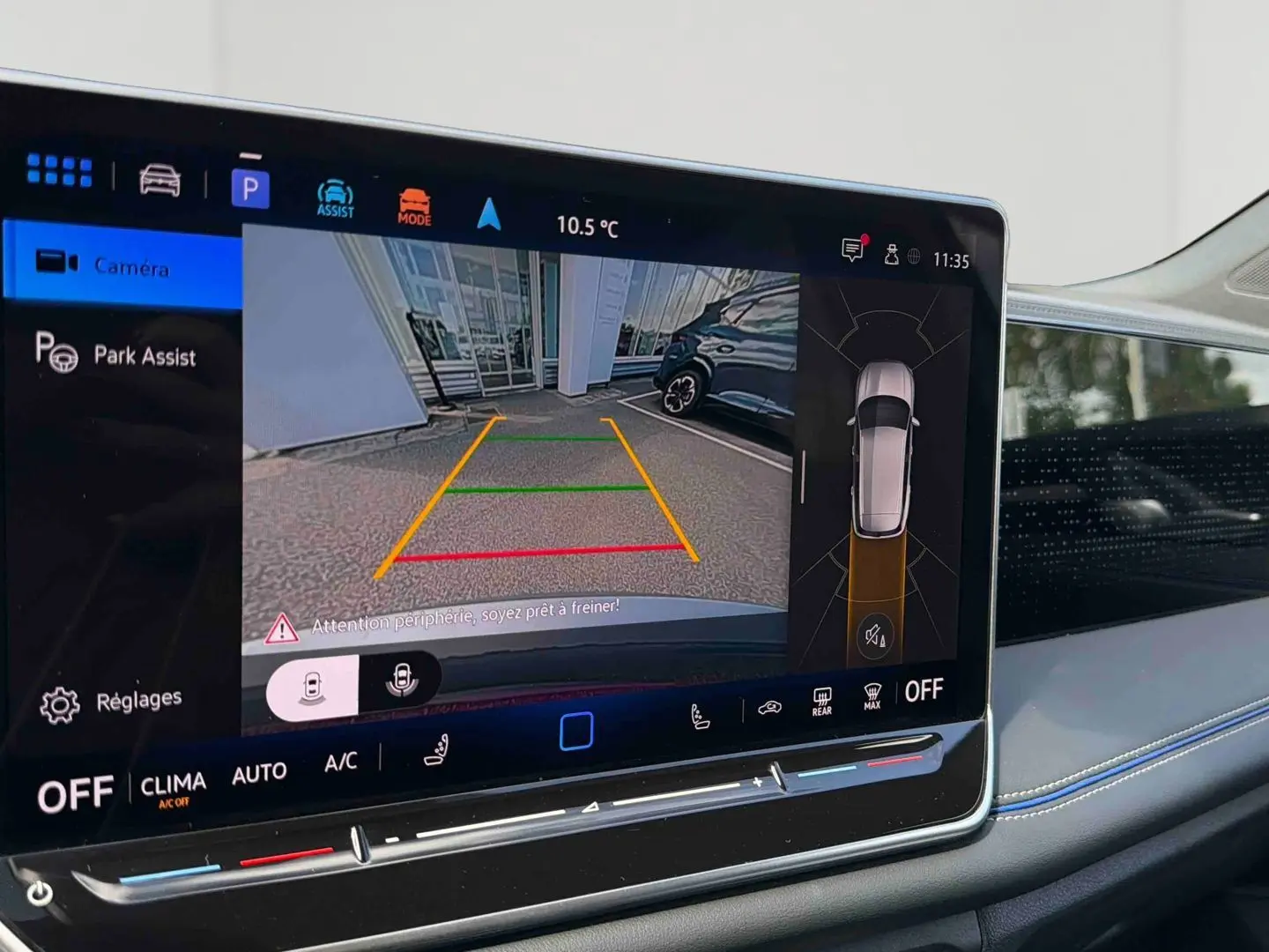 Écran tactile intérieur du Volkswagen Tiguan 2025 montrant l'assistance au stationnement en caméra de recul.