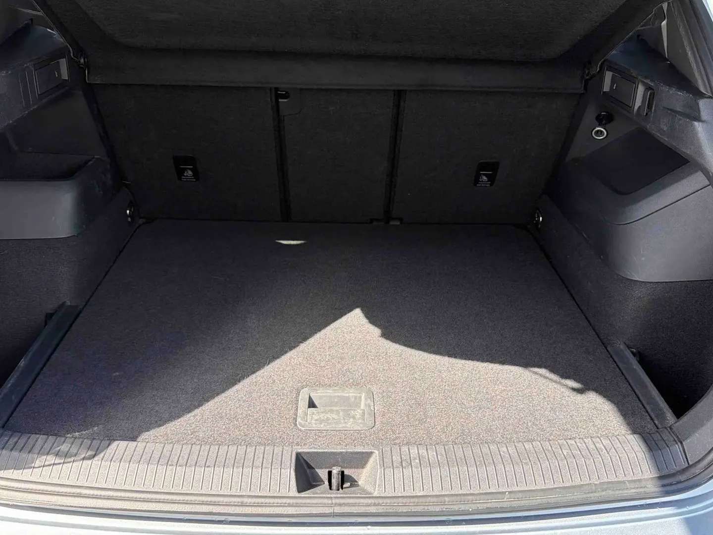 Coffre ouvert du Volkswagen Tiguan gris 2025, montrant un espace de chargement propre et bien agencé.