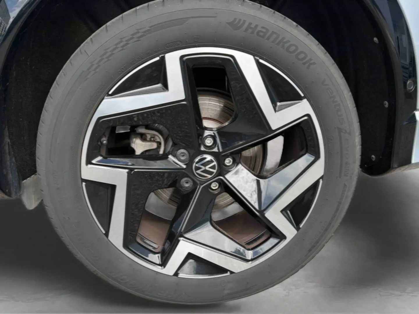 Gros plan sur la jante en alliage noir et brillant de 19 pouces du Volkswagen Tiguan gris, avec logo VW central.