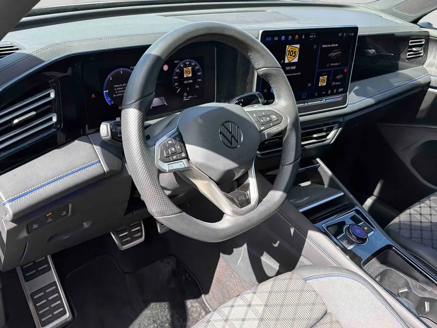 Vue intérieure côté conducteur du Volkswagen Tiguan 2025, volant cuir multifonction et écran tactile digital.