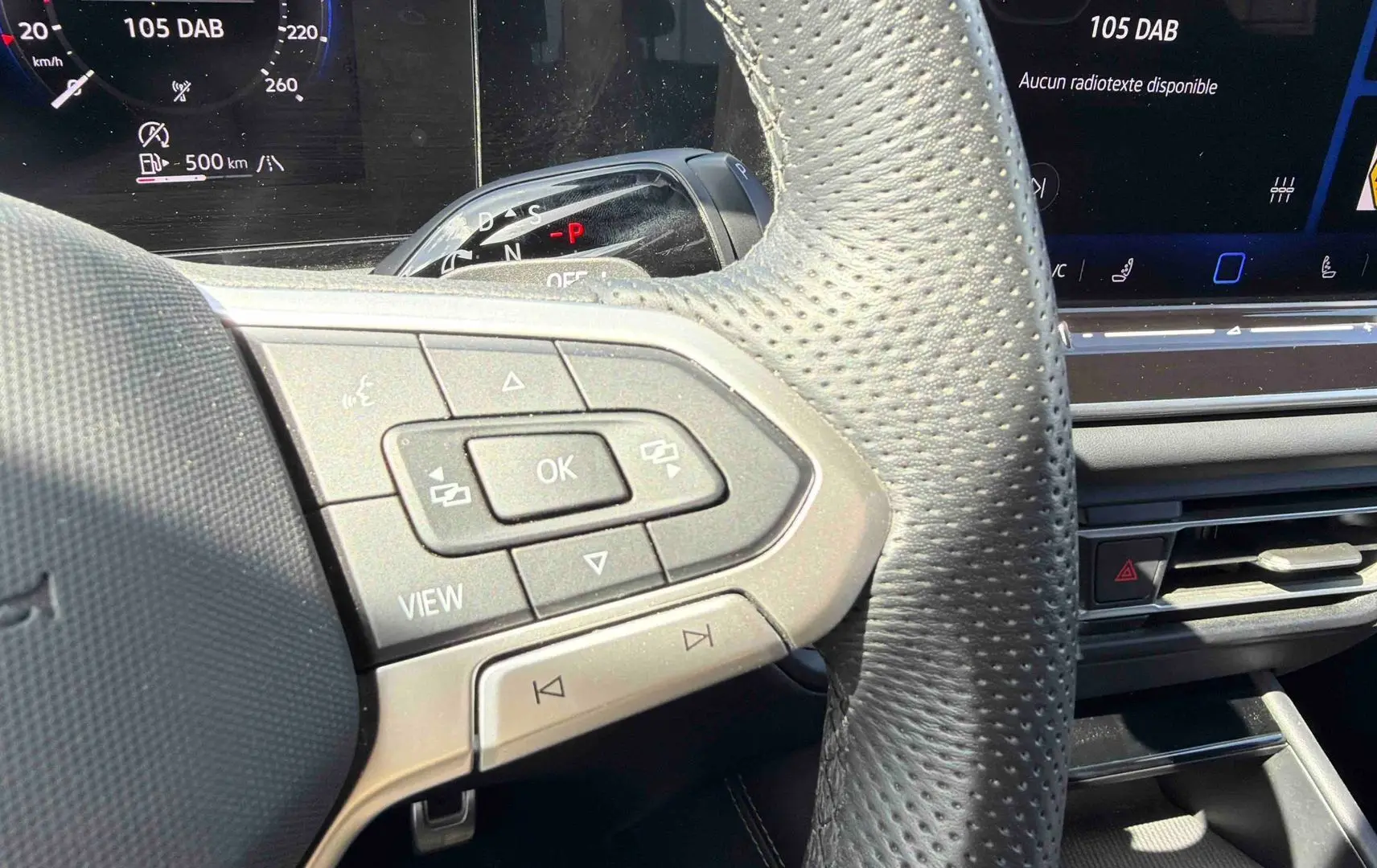Gros plan sur le volant cuir perforé et les commandes multifonctions du Volkswagen Tiguan 2025, intérieur noir.