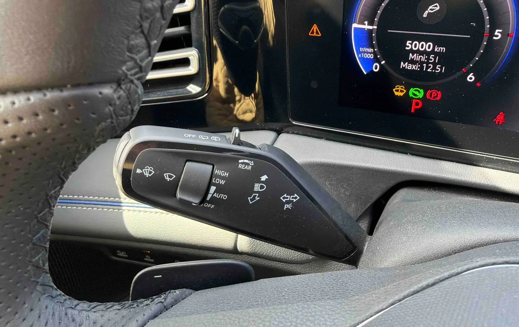 Gros plan sur la manette de commandes des essuie-glaces côté gauche du tableau de bord du Volkswagen Tiguan gris.