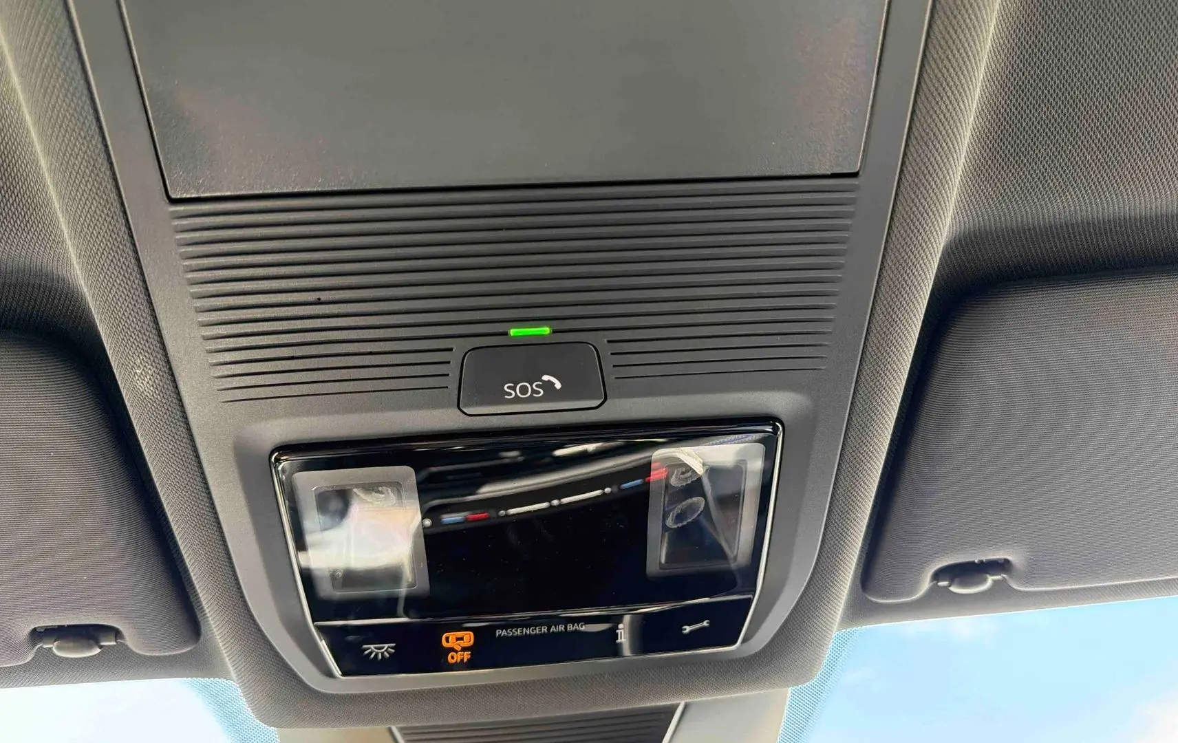 Plafonnier intérieur avec bouton SOS et éclairage, vue du toit d’un Volkswagen Tiguan gris 2025.
