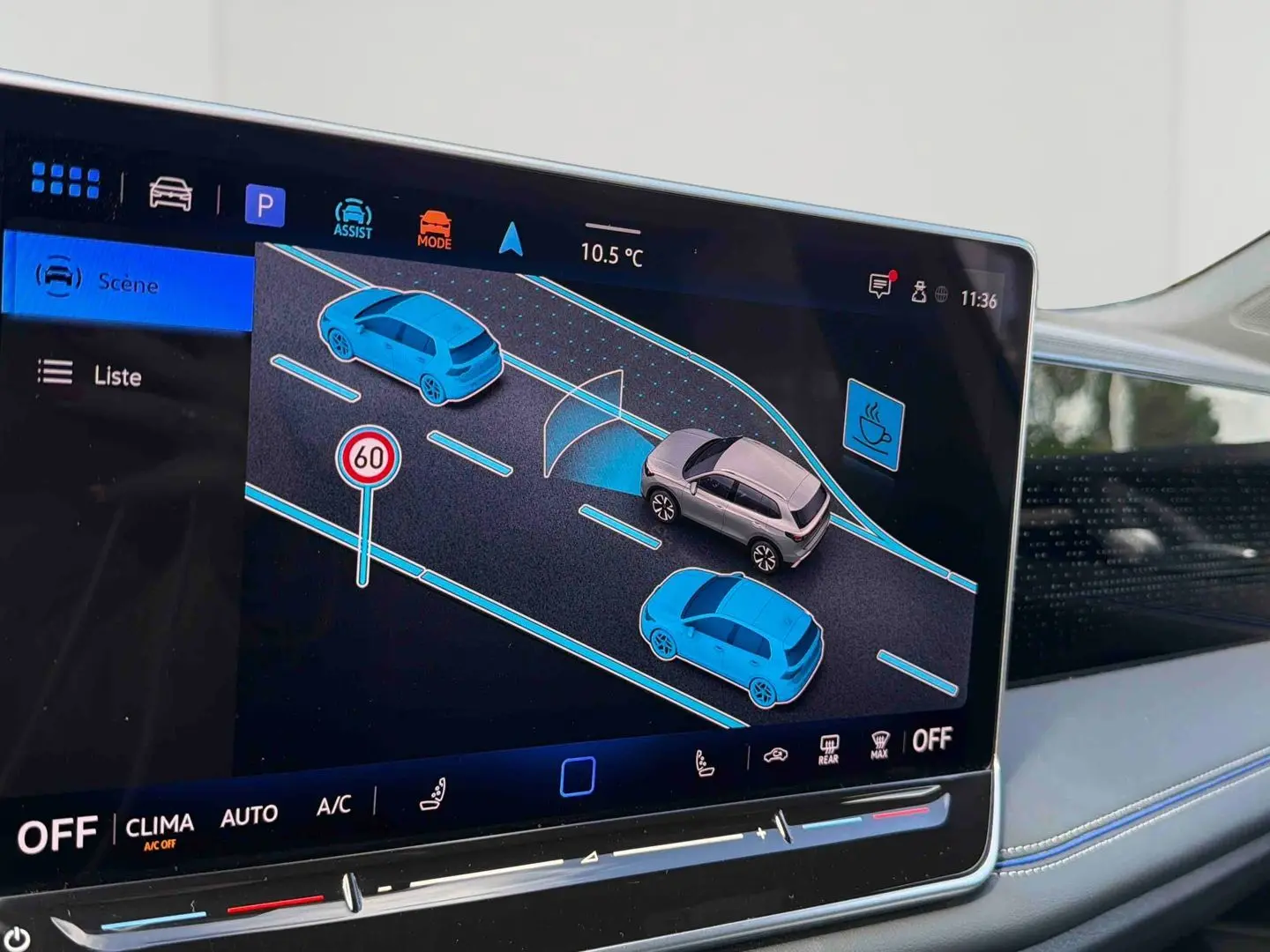 Écran tactile intérieur du Volkswagen Tiguan 2025 montrant l'assistance au maintien de voie et la détection des véhicules alentours.