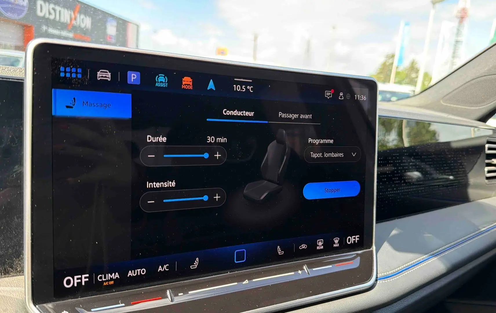 Écran tactile central du Volkswagen Tiguan 2025 montrant le réglage du massage siège côté passager, intérieur clair avec surpiqûres bleues.