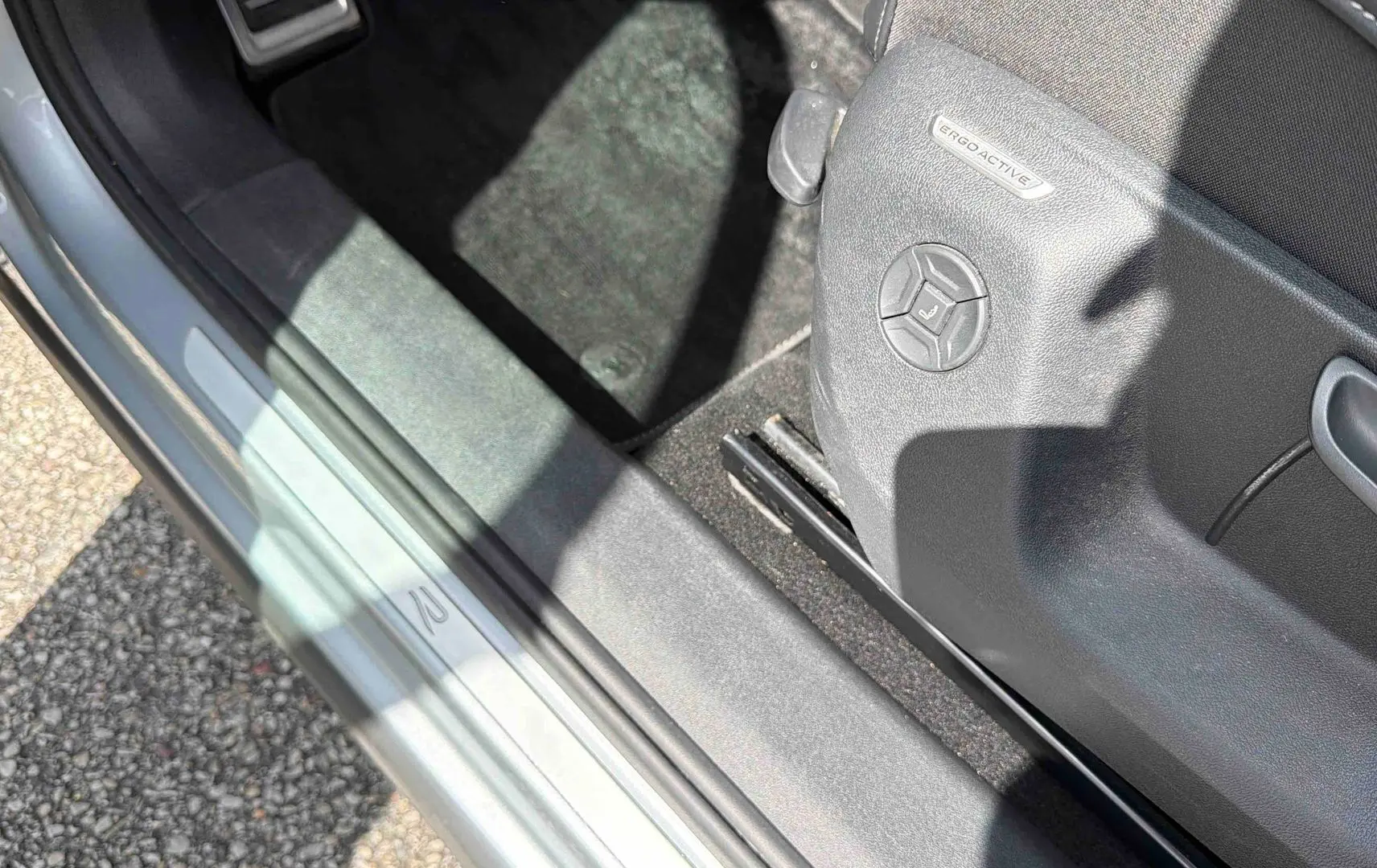 Détail de la porte côté conducteur du Volkswagen Tiguan gris 2025 avec siège ErgoActive et seuil de porte marqué R.