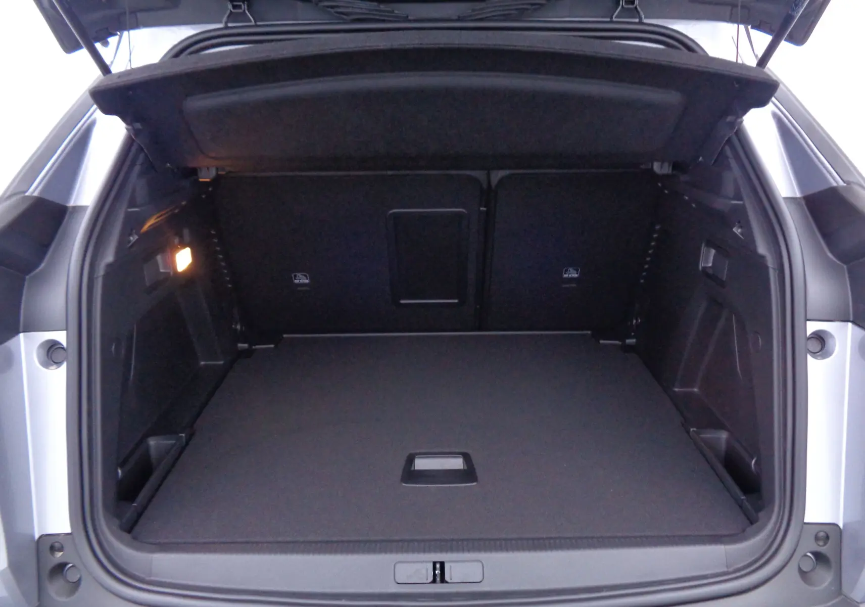 Coffre ouvert du Peugeot 3008 gris Artense Metal, montrant un espace de chargement propre et spacieux.