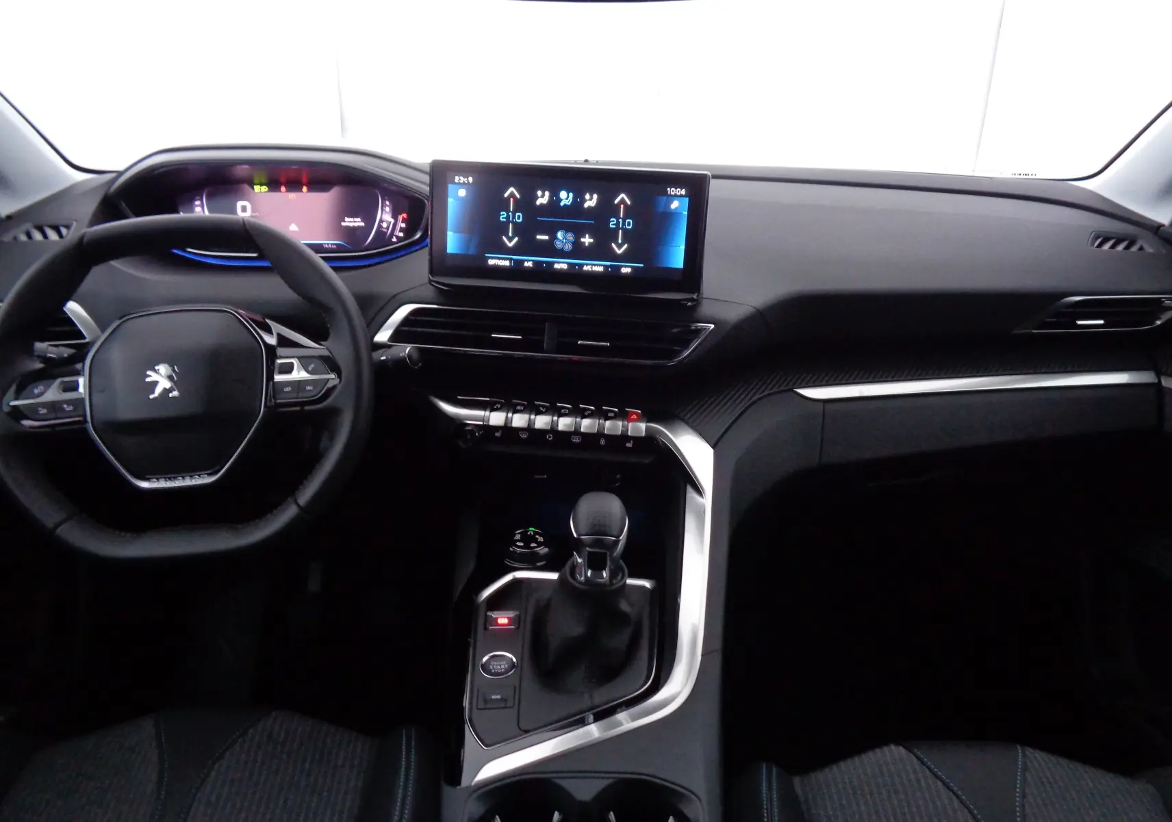 Vue intérieure frontale du Peugeot 3008 2023, tableau de bord moderne avec écran tactile et volant compact noir.