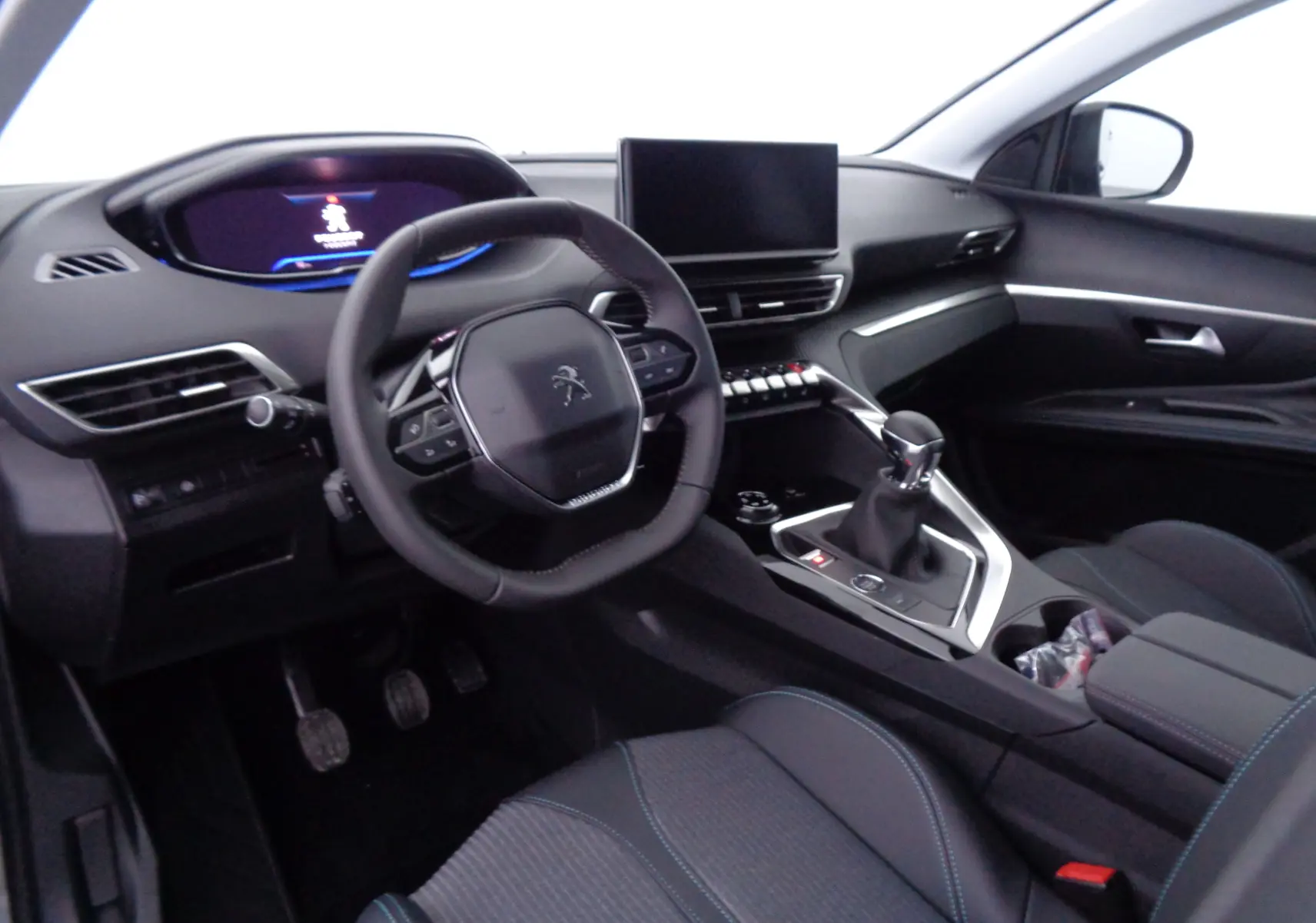 Intérieur Peugeot 3008 2023 vu côté conducteur, tableau de bord moderne avec écran tactile et volant compact noir.