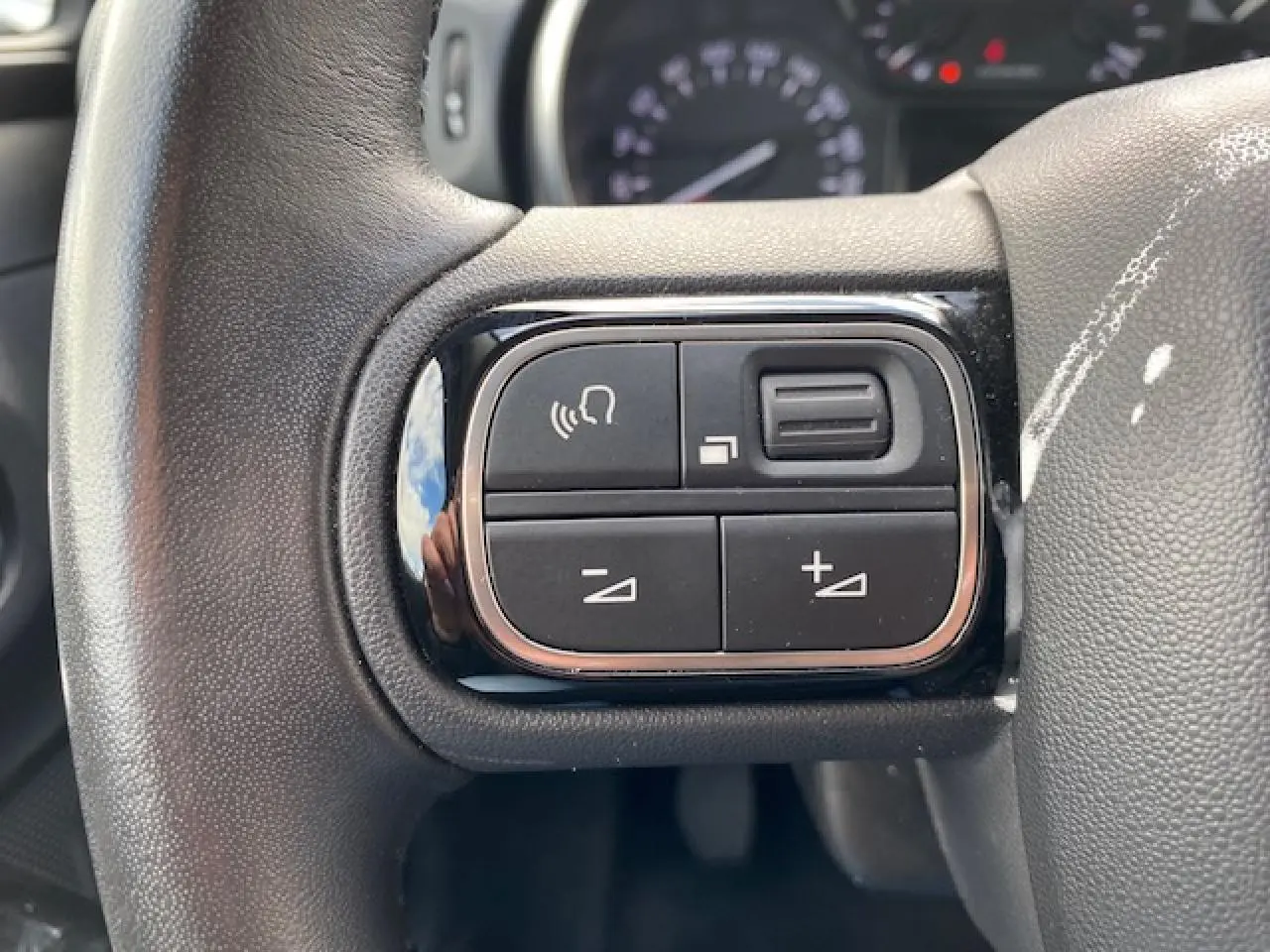 Gros plan sur les commandes de volume et de téléphone au volant d'une Citroën C3 2017, intérieur noir.