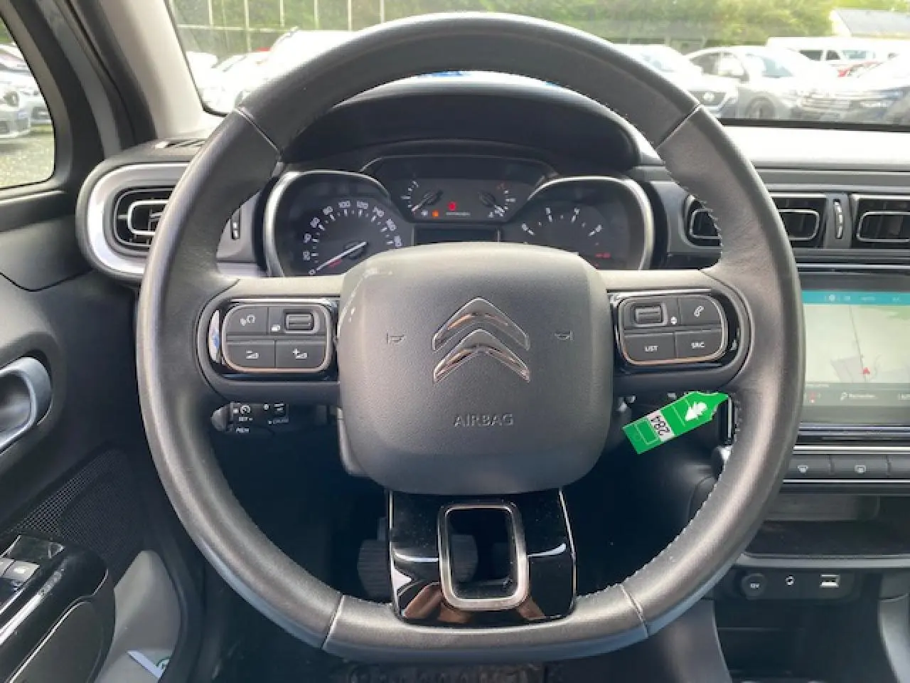 Vue frontale du volant noir de la Citroën C3 2017 avec tableau de bord et écran tactile GPS visible à droite.