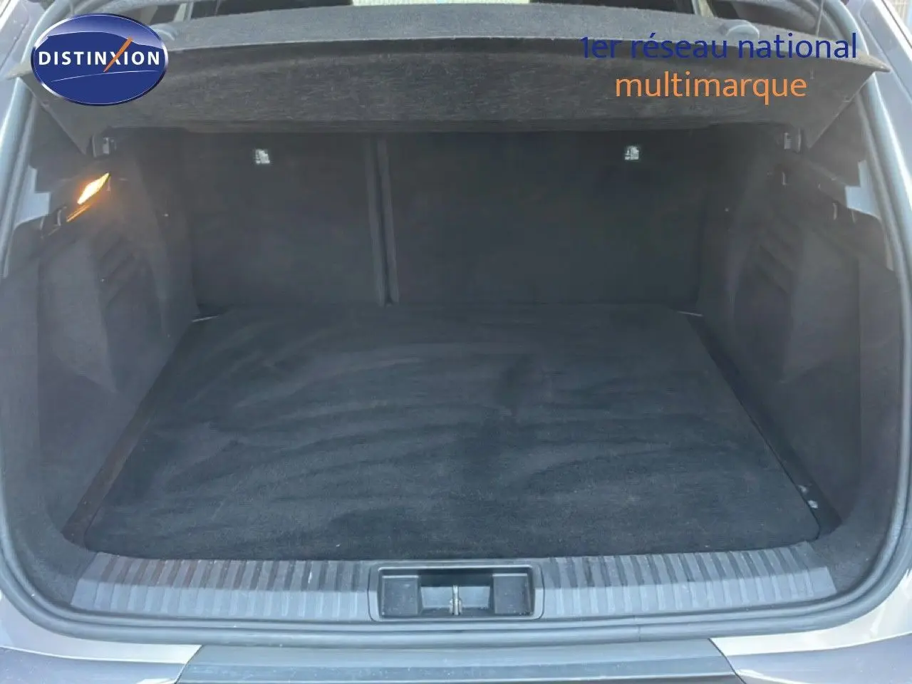 Coffre ouvert vu de l'arrière d'une Renault Symbioz gris cassiopée métal, montrant un espace de chargement propre et spacieux.