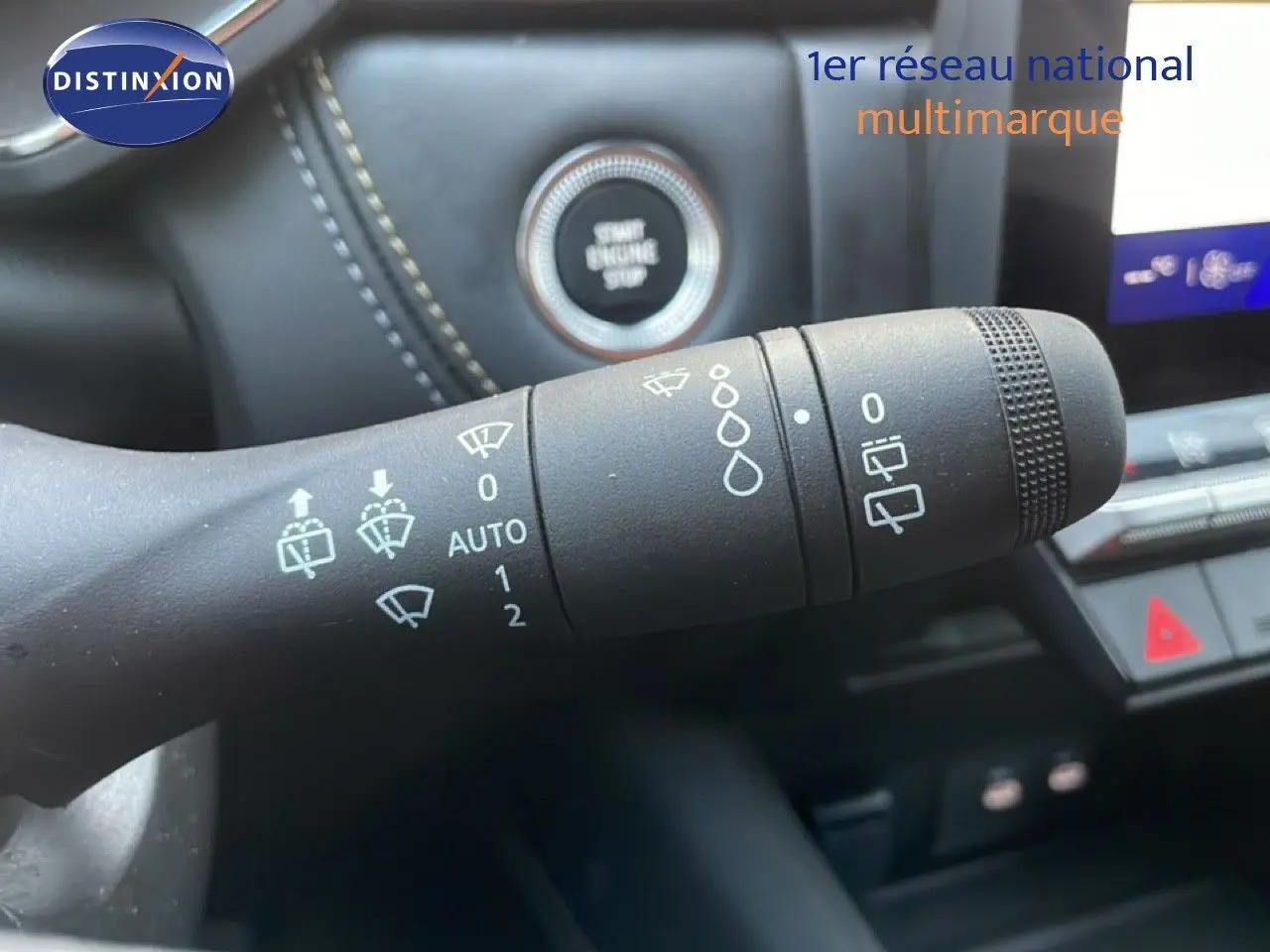 Gros plan sur la commande des essuie-glaces du Renault Symbioz gris cassiopée, avec bouton start engine visible en arrière-plan.