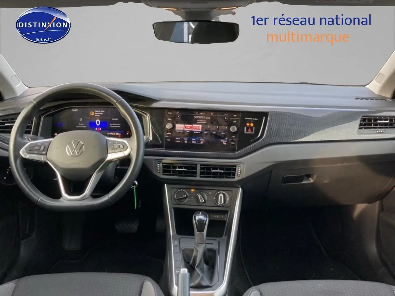 Vue intérieure avant du tableau de bord gris et noir de la Volkswagen Polo 1.0 TSI 95 VW Edition avec écran tactile et volant cuir.