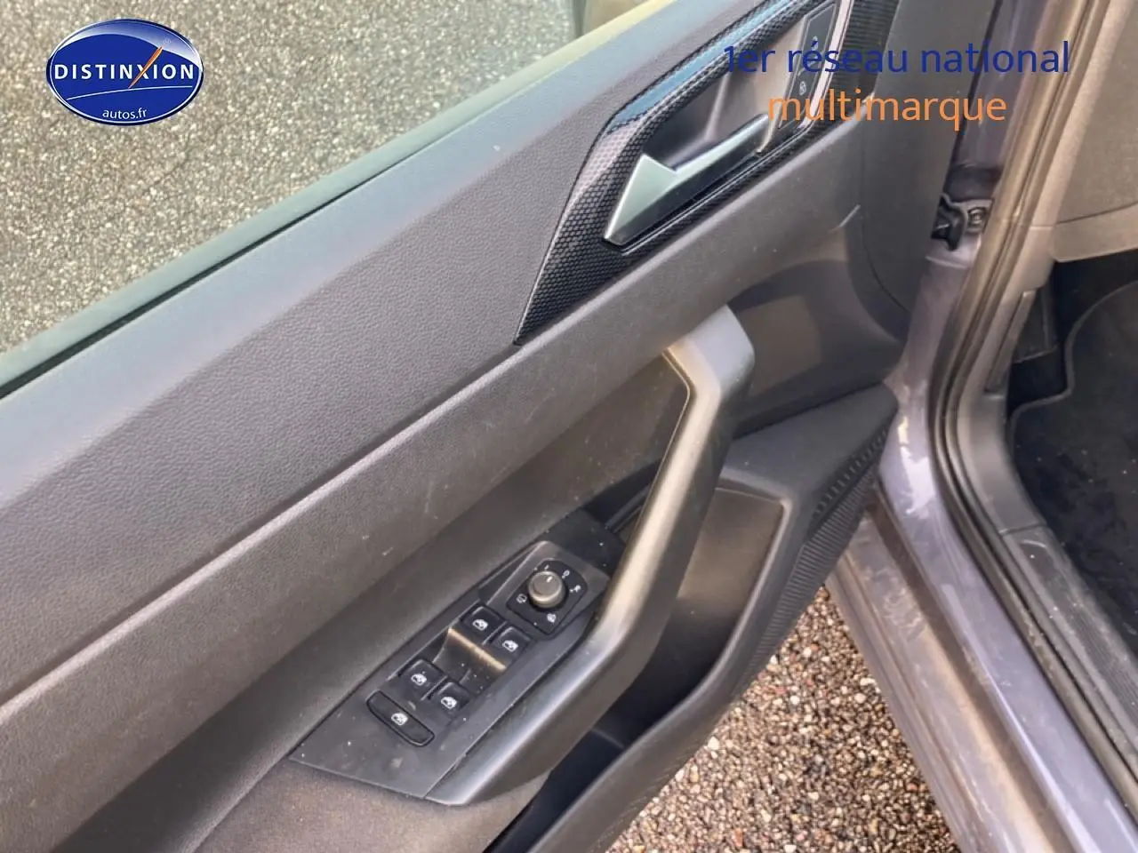 Vue rapprochée de la porte avant gauche gris cendre de la Volkswagen Polo 2025 avec commandes électriques des vitres et poignée intégrée.