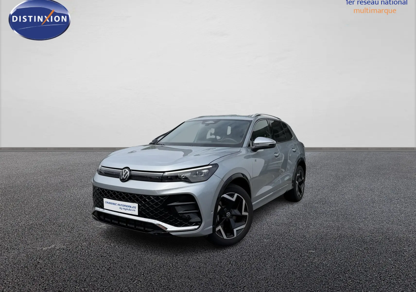 Volkswagen Tiguan gris en 3/4 avant droit avec jantes noires et calandre R-Line distinctive.