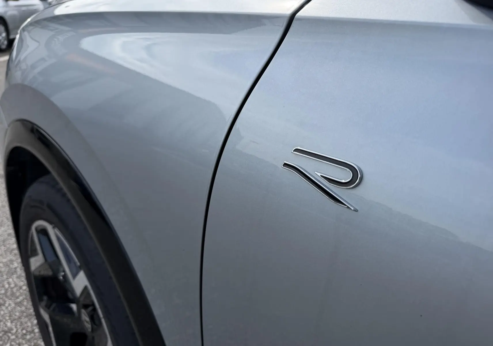 Gros plan sur l'aile avant gauche grise du Volkswagen Tiguan 2025 avec logo R distinctif.