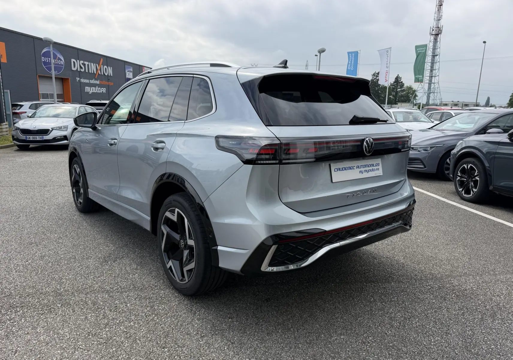 Volkswagen Tiguan gris 2025 vu 3/4 arrière droit, avec feux arrière LED 3D et jantes alliage noires.
