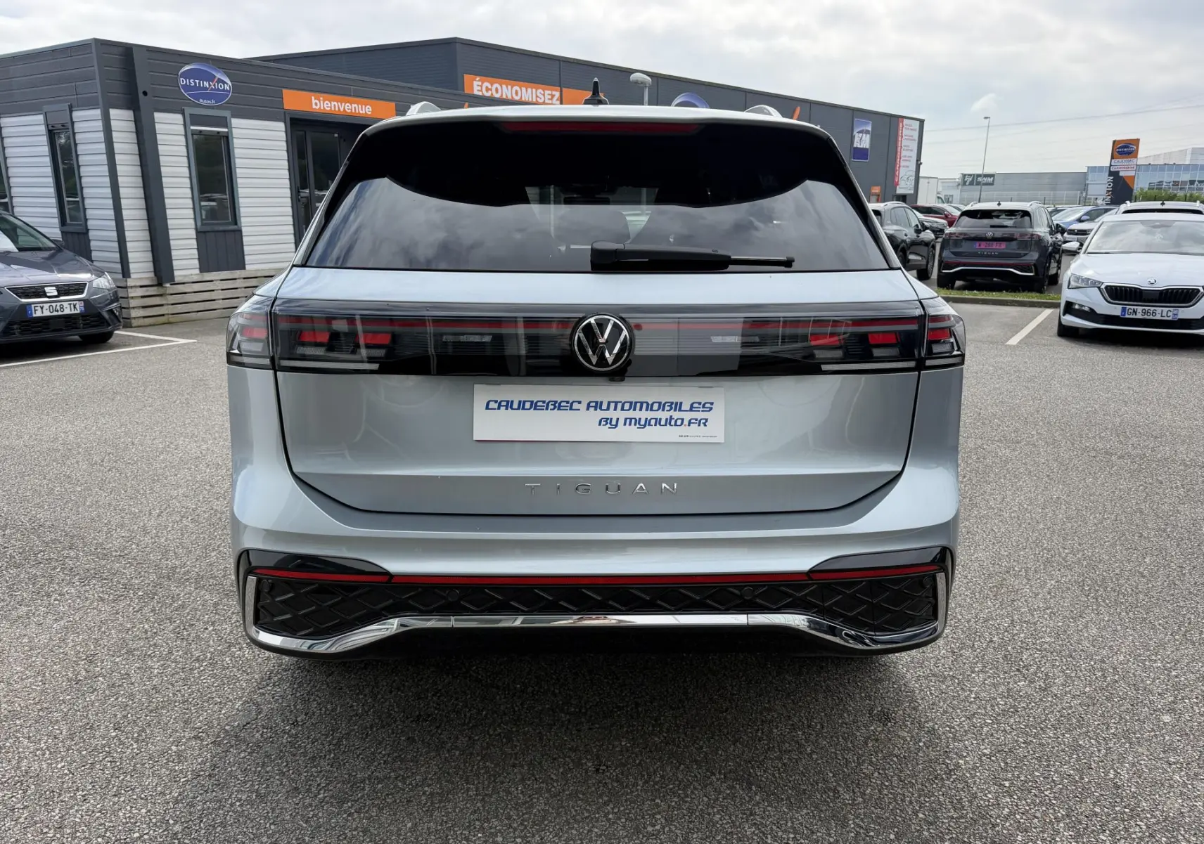Vue arrière d'un Volkswagen Tiguan gris 2025 avec feux arrière LED 3D et logo VW centré sur un parking.