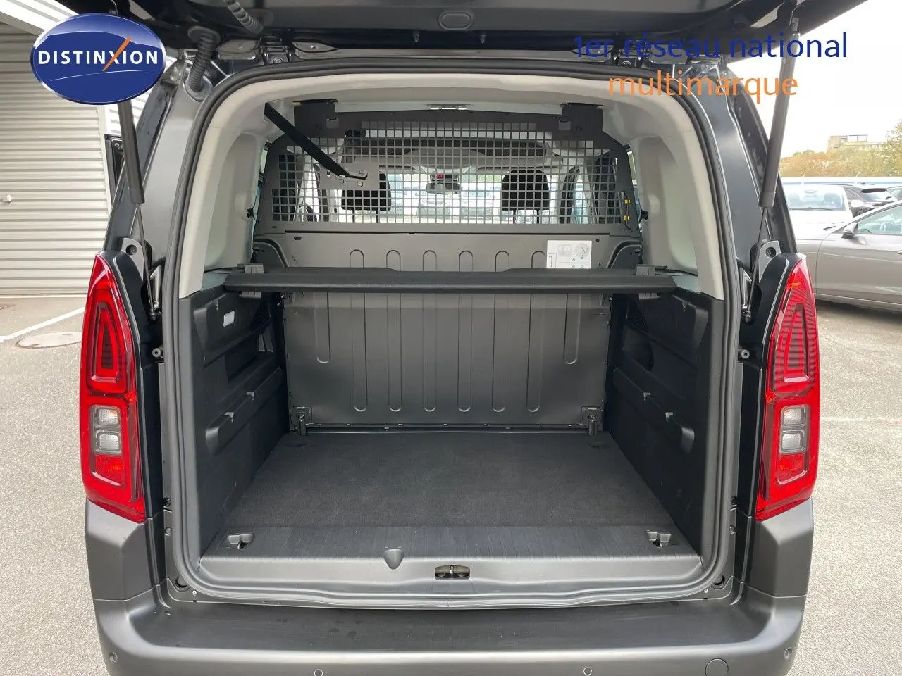 Vue arrière du Citroën Berlingo noir Perla Nera avec coffre ouvert et cloison métallique visible.
