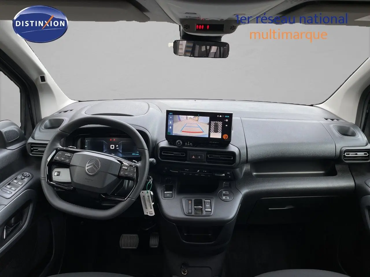 Tableau de bord et volant noir du Citroën Berlingo 2026, vue frontale avec écran central affichant la caméra de recul.