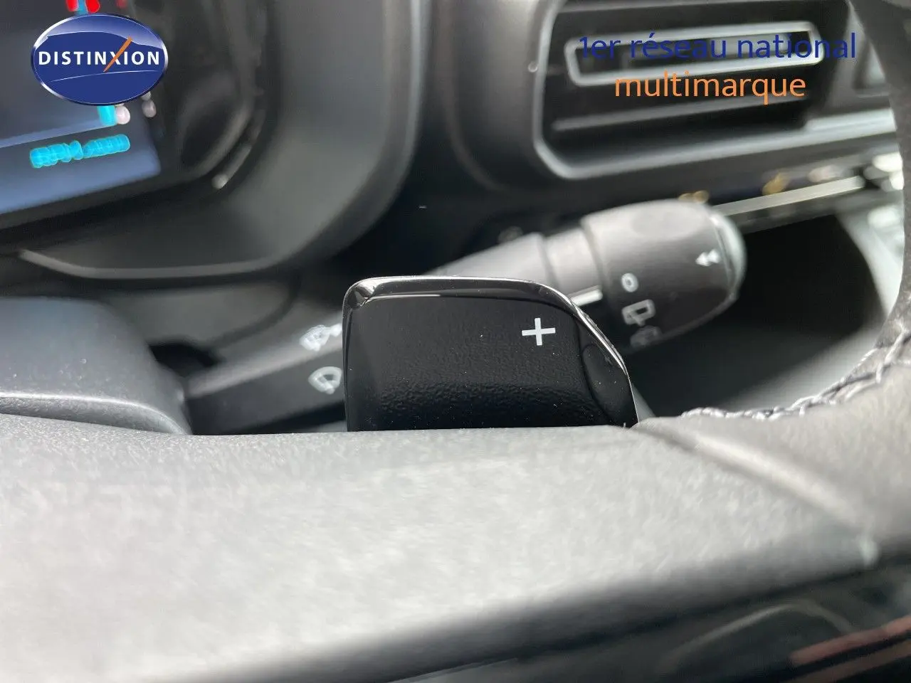 Gros plan sur la palette de changement de vitesse droite du volant d’un Citroën Berlingo noir Perla Nera, intérieur sombre.