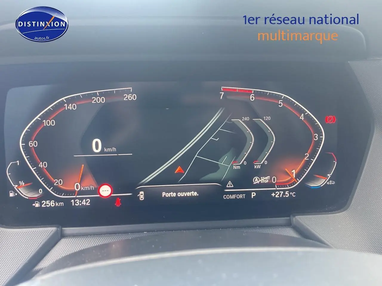 Tableau de bord numérique de BMW Série 1 (F40) 118i 2023 affichant vitesse, température et alertes, vue frontale rapprochée.