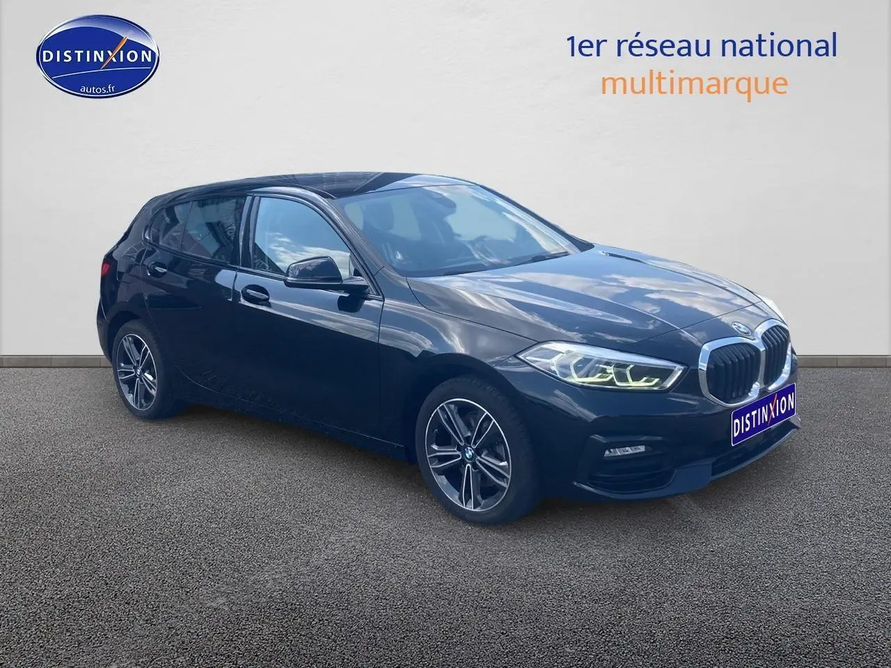 BMW Série 1 noire vue en 3/4 avant droit avec phares LED allumés et jantes alliage 17 pouces style 549.